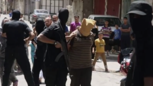 للتوضيح: مسلح تابع لحركة حماس يمسك ب’متعاون’ مزعوم في غزة، لحظات قبل إطلاق النار على المشتبه به وإعدامه، 22 أغسطس، 2014.(screenshot: YouTube)