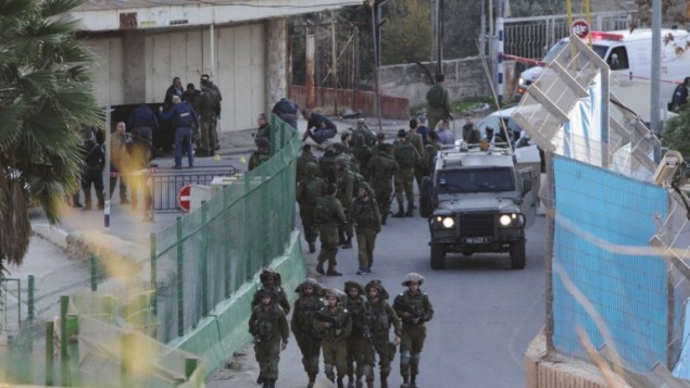 من الأرشيف: قوات إسرائيلية تحتشد في موقع تعرض فيه إسرائيلي للطعن بيد فلسطيني بالقرب من الحرم الإبراهيمي في الخليل، 7 ديسمبر، 2015. (AFP/Hazem Bader) من الأرشيف: قوات إسرائيلية تحتشد في موقع تعرض فيه إسرائيلي للطعن بيد فلسطيني بالقرب من الحرم الإبراهيمي في الخليل، 7 ديسمبر، 2015. (AFP/Hazem Bader)