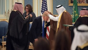 الرئيس الأمريكي دونالد ترامب (الوسط) يحصل على وسام الملك عبد العزيز آل سعود من الملك السعودي سلمان بن عبد العزيز آل سعود (من اليمين) في الديوان الملكي في الرياض، 20 مايو، 2017. (AFP PHOTO / MANDEL NGAN)