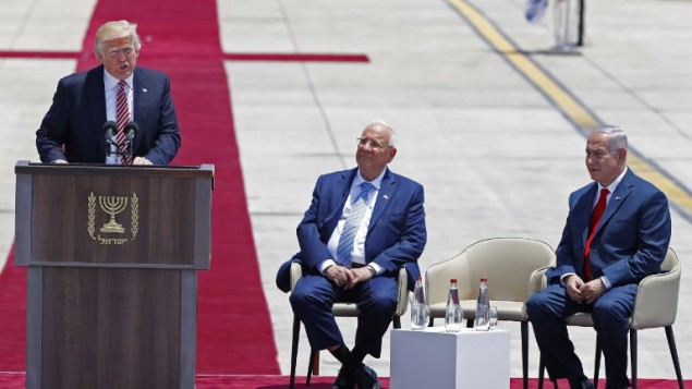 الرئيس الأمريكي دونالد ترامب يلقي خطابا عند وصوله إلى مطار بن غوريون الدولي، بينما يستمع الرئيس الإسرائيلي رؤوفن ريفلين ورئيس الوزراء بنيامين نتنياهو، 22 مايو 2017 (AFP PHOTO / Jack GUEZ)