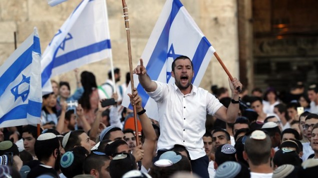 اسرائيليون يلوحون بالاعلام الإسرائيلية خلال مسيرة حول القدس القديمة، احتفال بيوم القدس، في الذكرى الخمسين لتوحيد المدينة بعد حرب 1967، 24 مايو 2017 (AFP PHOTO / Menahem KAHANA)