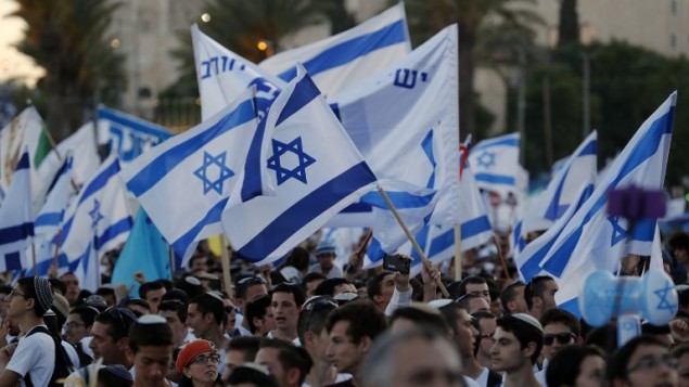 اسرائيليون يلوحون بالاعلام الإسرائيلية خلال مسيرة حول القدس القديمة، احتفال بيوم القدس، في الذكرى الخمسين لتوحيد المدينة بعد حرب 1967، 24 مايو 2017 (AFP PHOTO / Menahem KAHANA)