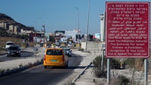 يافطة حمراء على جانب الطريق تحذر المواطنين الإسرائيليين من دخول مدينة نابلس في الضفة الغربية، 20 يوليو، 2015. (Garrett Mills/Flash90)