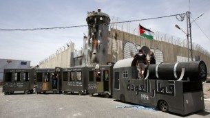 فلسطينيون يقفون على مجسم قطار في 15 مايو، 2016 أمام الجدار الفاصل الإسرائيلي خلال تظاهرة لإحياء ذكرى ’النكبة’. (AFP PHOTO / HAZEM BADER)
