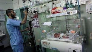 صورة توضيحية لممرض فلسطيني مع  حديث الولادة في وحدة العناية المركزة لحديثي الولادة في مستشفى الإمارات في رفح بجنوب قطاع غزة في 27 يونيو / حزيران 2017. (SAID KHATIB / AFP)