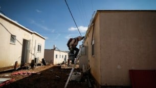 عمال بناء يعملون على تنظيف الأرض لكرافانات جديدة في مستوطنة عوفرا اليهودية، في الضفة الغربية، 29 يناير، 2017. (Yaniv Nadav/FLash90)