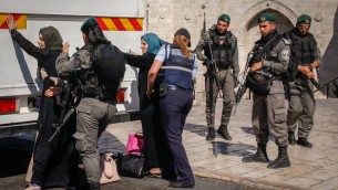 عناصر قوات امن اسرائيليين يفتشون نساء فلسطينيان امام باب العامود في القدس القديمة، قبل السماح لهن الصعود على متن حافلة متجهة الى الضفة الغربية، 17 يونيو 2017 (Sliman Khader/Flash90)