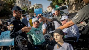 متظاهر يحاول إضرام النار في نفسه خلال تظاهرة للمطالبة بزيادة مخصصات الإعاقة أمام مقر إقامة رئيس الوزراء في القدس، 27 يونيو، 2017. (Yonatan Sindel/Flash90)