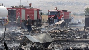 رجال اطفاء لبنانيون يفحصون الاضرار الناتجة عن حريق ضخم في مخيم لاجئين سوريين في لبنان، 2 يوليو 2017 (HASSAN JARRAH / AFP)