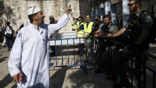 رجل فلسطيني امام حرس حدود اسرائيليين بالقرب من بوابات كشف المعادن عند المدخل الرئيسي للحرم القدسي، 16 يوليو 2017 (AFP PHOTO / AHMAD GHARABLI)