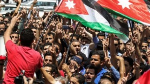 يحتج المتظاهرون الأردنيون  خلال مظاهرة بالقرب من السفارة الإسرائيلية في العاصمة عمان في 28 يوليو / تموز 2017، رافعين الأعلام الوطنية ويهتفون بالشعارات,  مطالبون بإغلاق السفارة وطرد السفيرة وإلغاء معاهدة السلام عام 1994 مع إسرائيل. (AFP PHOTO / KHALIL MAZRAAWI)