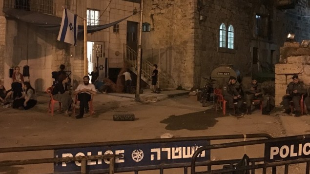 المستوطنون في منزل استولى عليه مستوطنين في الخليل يجلسون خارج المبنى بجوار عناصر حرس الحدود، 26 يوليو 2017 (Jacob Magid) المستوطنون في منزل استولى عليه مستوطنين في الخليل يجلسون خارج المبنى بجوار عناصر حرس الحدود، 26 يوليو 2017 (Jacob Magid)