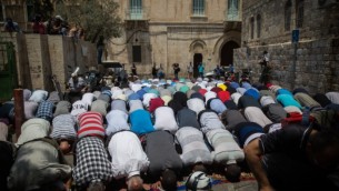 مصلون مسلمون يؤدون الصلاة عند مدخل الحرم القدسي عند باب الأسباط في البلدة القديمة لمدينة القدس، 25 يوليو، 2017. لا يزال المصلون المسلمون يرفضون الصلاة في الحرم القدسي بعد قرار الحكومة الإسرائيلية إزالة البوابات الإلكترونية ووضع كاميرات أمن بدلا منها في المجمع. (Hadas Parush/Flash90)