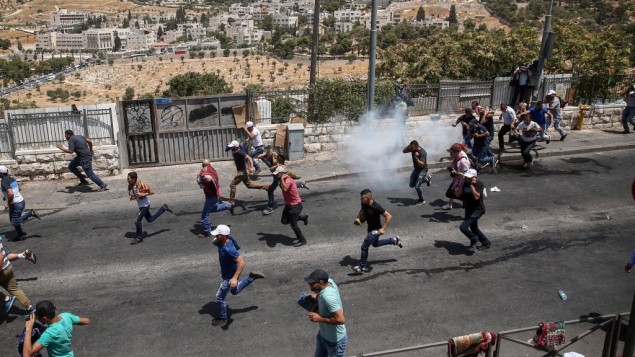 متظاهرون فلسطينيون يهربون من قنابل الغاز المسيل للدوع بعد صلاة الجمعة في حي وادي الجوز في القدس الشرقية، 28 يوليو 2017 (Miriam Alster/Flash90)