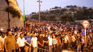 يشارك الآلاف من المصلين المسلمين في صلاة المغرب خارج بوابة الأسباط في البلدة القديمة من القدس، رافضين دخول الحرم القدسي للوصول إلى المسجد الأقصى في الداخل، 25 يوليو / تموز 2017. (Dov Lieber /Times of Israel)