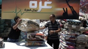 فلسطينيون يجمعون السلع والأغطية في القدس الشرقية، يوم الخميس، 14 أغسطس، 2014، والتي سيتم ارسالها وتوزيعها مع الصليب الأحمر إلى المحتاجين في قطاع غزة. (AFP/AHMAD GHARABLI)