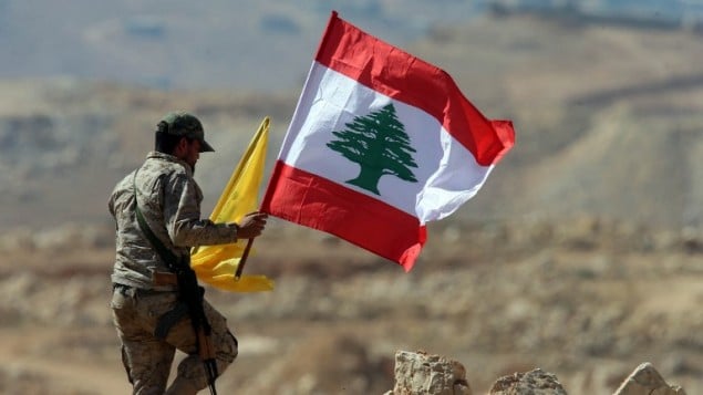 يحمل أحد عناصر حزب الله اللبناني وأعلام حزب الله ولبنان خلال جولة صحفية بالقرب من بلدة عرسال الحدودية في 25 يوليو / تموز 2017. (AFP Photo/Stringer) يحمل أحد عناصر حزب الله اللبناني وأعلام حزب الله ولبنان خلال جولة صحفية بالقرب من بلدة عرسال الحدودية في 25 يوليو / تموز 2017. (AFP Photo/Stringer)