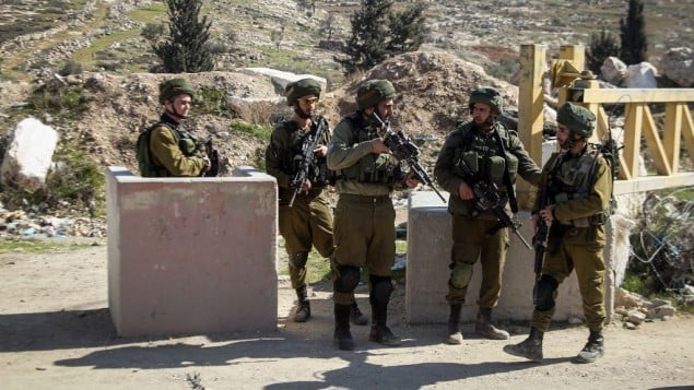 صورة توضيحية: جنود اسرائيليون يفتشون سيارات فلسطينية في حاجز في بلدة يطا بالضفة الغربية، 10 فبراير 2017 (Wisam Hashlamoun/Flash90)
