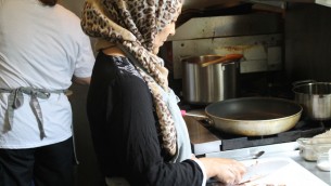 نسيمة، لاجئة من أفغانستان التي لم تعط اسمها عائلتها، تقطع الفطر لطهي الشكشوكة، 11 أغسطس 2017. (Ben Sales/JTA)