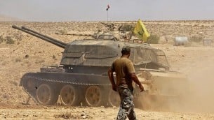 دبابة تحمل علما لمنظمة ’حزب الله’ في منطقة مدينة قارة في منطقة القلمون السورية، 28 أغسطس، 2017. (AFP Photo/Louai Beshara)