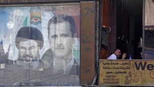 ملصق يحمل صورة الرئيس الصوري بشار الأسد (من اليمين) والأمين العام لمنظمة ’حزب الله’ حسن نصر الله في دمشق، 7 سبتمبر، 2017. ( AFP/LOUAI BESHARA )