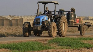 مزارع يعود من العمل في الدفيئة في كيبوتس ناحال عوز، بالقرب من الحدود بين إسرائيل وغزة.  (Tsafrir Abayov/Flash90)