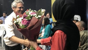 مؤسس منظمة ’تاغ مئير’ غادي غفرياهو يهدي باقة زهور لميرفت إغبارية، طالبة جامعية اعتقد أحد الركاب عن طريق الخطأ على متن حافلة إلى بئر السبع إنها تعتزم تنفيذ هجوم. (Gabriel Carrol/Times of Israel)