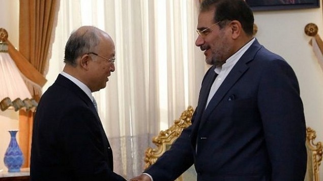 الأمين العام للمجلس الأعلى للأمن القومي الإيراني، علي شمخاني، من اليمين، يصافح رئيس الوكالة الدولية للطاقة الذرية يوكيا أمانو خلال لقاء جمعهما في طهران، 2 يوليو، 2015. (AFP/ATTA KENARE)