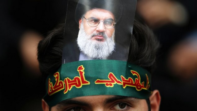 مؤيد لمنظمة ’حزب الله’ يضع على رأسه صورة للأمين العام للمنظمة حسن نصر الله خلال إحياء ’يوم عاشوراء’ في الضاحية الجنوبية للعاصمة اللبنانية بيروت، 1 أكتوبر، 2017. ( AFP PHOTO / ANWAR AMRO) مؤيد لمنظمة ’حزب الله’ يضع على رأسه صورة للأمين العام للمنظمة حسن نصر الله خلال إحياء ’يوم عاشوراء’ في الضاحية الجنوبية للعاصمة اللبنانية بيروت، 1 أكتوبر، 2017. ( AFP PHOTO / ANWAR AMRO)