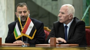 عزام الاحمد من حركة فتح (يمين) وصالح العاروري من حركة حماس، يتحدثان مع الصحافة بعد التوقيع على اتفاق المصالحة بين الفصيلين في القاهرة، 12 اكتوبر 2017 (AFP/Khaled Desouki)