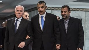 رئيس جهاز المخابرات المصرية خالد فوزي، وسط الصورة، يصل برفقة المسؤول في حركة ’فتح’ عزام الأحمد، من اليسار، والمسؤول في ’حماس’ صالح العاروري، من اليمين، قبل التوقيع  على اتفاق المصالحة في القاهرة في 12 أكتوبر، 2017. (AFP/ KHALED DESOUKI)