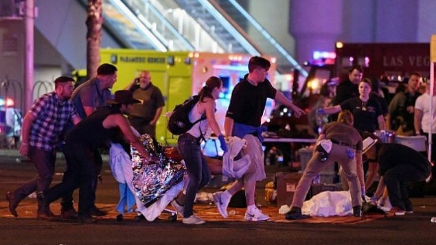 تقديم العلاج لشخص مصاب عند تقاطع جادة ’تروبيكانا’ وجادة ’لاس فيغاس’ بعد هجوم إطلاق نار في حفل موسيقي في 2 أكتوبر، 2017، في مدينة لاس فيغاس بولاية نيفادا. (Ethan Miller/Getty Images/AFP)