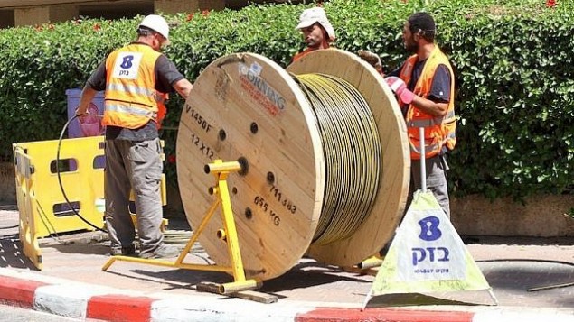 عمال بيزك يركبون كوابل الألياف البصرية. (Courtesy)