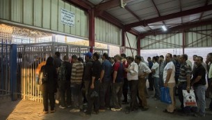 عمال فلسطينيون ينتظون عبر نقطة التفتيش من مدينة رام الله في الضفة الغربية للعمل في إسرائيل، 4 يونيو، 2013. (Yonatan Sindel/Flash90)
