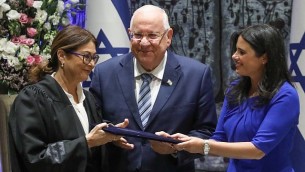 رئيس الدولة رؤوفين ريفلين ووزيرة العدل أييليت شاكيد يقفان إلى جانب رئيسة محكمة العدل العليا الجديدة إستر حايوت خلال إدائها لليمين القانونية في مقر إقامة رئيس الدولة في القدس، 26 أكتوبر، 2017. (Miriam Alster/Flash90)