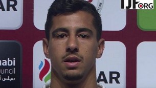 لاعب الجودو تال فليكر، الحائز على ميدالية ذهبية، ينشد النشيد الوطني الإسرائيلي على الرغم من رفض المسؤولين المحليين اسماعه في الجودو غراند-سلام في أبو ظبي، حيث حظرت سلطات الجودو المحلية جميع الرموز الإسرائيلية، 26 أكتوبر / تشرين الأول 2017. (YouTube screen capture)