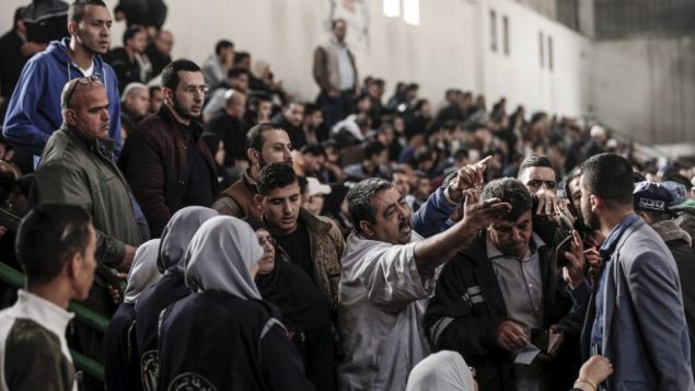 فلسطينيون يتشاجرون مع مسؤولين من حركة حماس في خان يونس اثناء الانتظار لركوب حافلات تنقلهم عبر معبر رفح الحدودي مع مصر، بعد افتتاحه لثلاث ايام لأول مرة بعد تحقيق اتفاق المصالحة الفلسطينية، 18 نوفمبر 2017 (AFP PHOTO / Mahmud Hams)