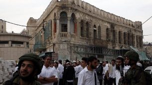 مستوطنون إسرائيليون ترافقهم قوات إسرائيلية خلال جولة في الجاب الفلسطيني من مدينة الخليل المقسمة، 18 نوفمبر، 2017. (AFP PHOTO / HAZEM BADER)