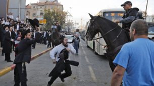 شرطي يفرق مظاهرة لليهود المتشددين ضد التجنيد العسكري في بني براك، 20 نوفبمر 2017 (AFP Photo/Ahmad Gharabli)