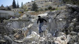 صورة توضيحية لرجل فلسطيني فوق حطام منزل تم هدمه في حي الطور في القدس الشرقية، 26 مارس 2014 (Sliman Khader/Flash90)