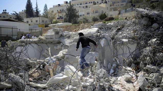 صورة توضيحية لرجل فلسطيني فوق حطام منزل تم هدمه في حي الطور في القدس الشرقية، 26 مارس 2014 (Sliman Khader/Flash90)