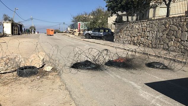 مستوطنون إسرائيليون يضعون حواجز مشتعله وأسلاك شائطة لمنع قوات الأمن من إخلائهم من  بؤرة نتيف هأفوت الاستيطانية غير القانونية في الضفة الغربية، 29 نوفمبر، 2017. (Times of Israel)