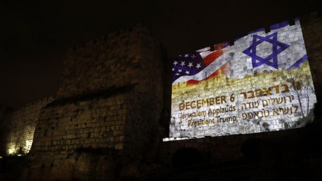 العلم الأميركي مع العلم الإسرائيلي على جدران المدينة القديمة في القدس، 6 ديسمبر 2017 (AFP/Ahmad GHARABLI)