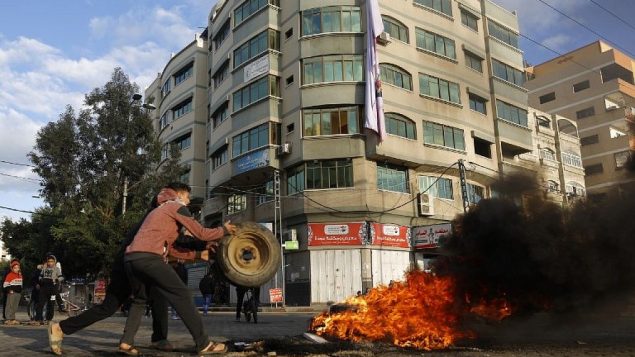 شبان فلسطينيون يشعلون اطارات خلال مظاهرة ضد اعتراف الرئيس الامريكي دونالد ترامب بالقدس كعاصمة اسرائيل، في مدينة غزة، 7 ديسمبر 2017 (MOHAMMED ABED/AFP) شبان فلسطينيون يشعلون اطارات خلال مظاهرة ضد اعتراف الرئيس الامريكي دونالد ترامب بالقدس كعاصمة اسرائيل، في مدينة غزة، 7 ديسمبر 2017 (MOHAMMED ABED/AFP)