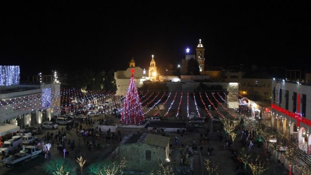 صورة تم التقاطها في 23 ديسمبر، 2017 لزينة عيد الميلاد في ساحة المهد وكنيسة المهد (في الخلفية) في مدينة بيت لحم  في الضفة الغربية. (AFP PHOTO / Musa EL SHAER)
