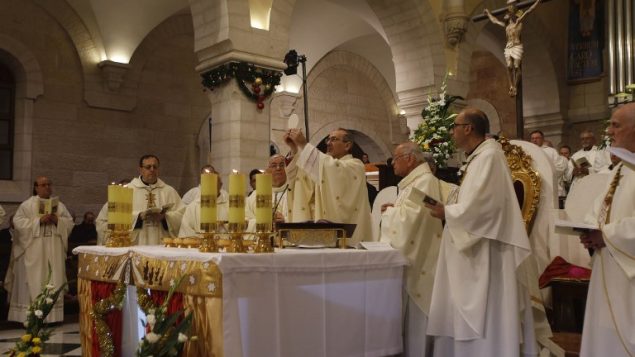 المدبر الرسولي لبطريركية اللاتين في القدس بيير باتيستا بيتسابالا يترأس قداس منتصف الليل بمناسبة عيد الميلاد في كنيسة المهد في مدينة بيت لحم في الضفة الغربية، 25 ديسمبر، 2017. (AFP PHOTO / POOL / MUSSA QAWASMA)