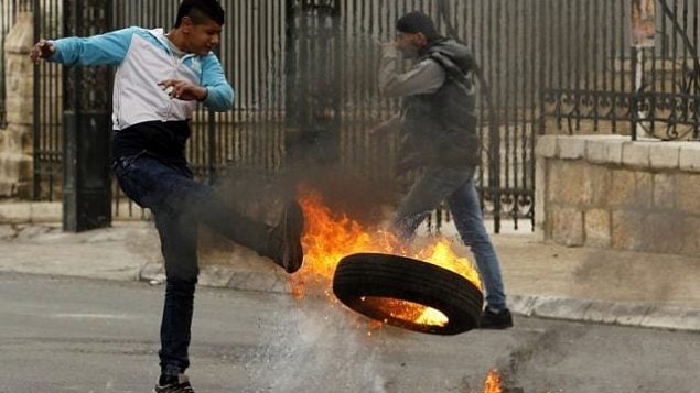 يشن متظاهر فلسطيني اطار مشتعل اثناء اشتباكات مع القوات الاسرائيلية في مدينة بيت لحم بالضفة الغربية في 29 كانون الاول 2017 بعد صلاة الجمعة. (AFP / Musa al Shaer)