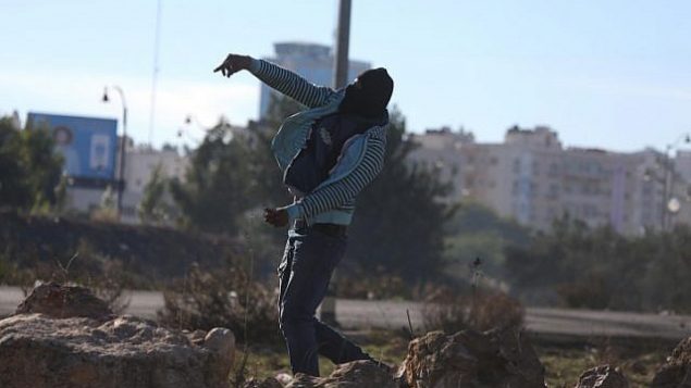 متظاهر فلسطيني يلقي حجرا باتجاه قوات الأمن الإسرائيلية خلال مواجهات عنيفة بالقرب من حاجز في مدينة رام الله في الضفة الغربية، 9 ديسمبر، 2017. (Flash 90) متظاهر فلسطيني يلقي حجرا باتجاه قوات الأمن الإسرائيلية خلال مواجهات عنيفة بالقرب من حاجز في مدينة رام الله في الضفة الغربية، 9 ديسمبر، 2017. (Flash 90)