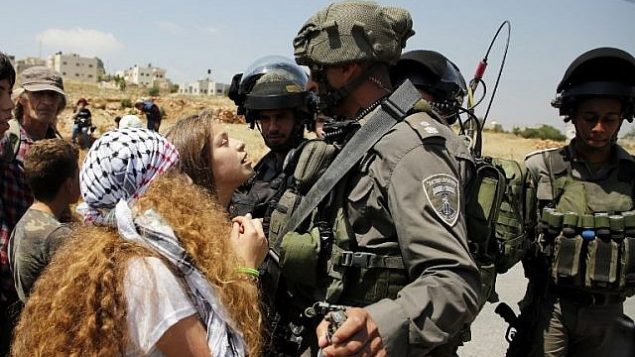 هذه الصورة من الأرشيف تم التقاطها في 12 مايو، 2017 لعهد التميمي (في وسط الصورة) خلال احتجاج أمام الجنود الإسرائيليين في قرية النبي صالح، شمال رام الله، في الضفة الغربية، بعد مظاهرة أجريت عقب صلاة الجمعة تضامنا مع الأسرى الفلسطينيين المضربين عن الطعام في السجون الإسرائيلية. (AFP/ ABBAS MOMANI)