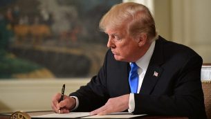 الرئيس الأمريكي دونالد ترامب يوقع مذكرة بعد أن أدلى ببيان عن القدس من غرفة الاستقبال الدبلوماسي في البيت الأبيض في واشنطن العاصمة يوم 6 ديسمبر 2017. (MANDEL NGAN/AFP)